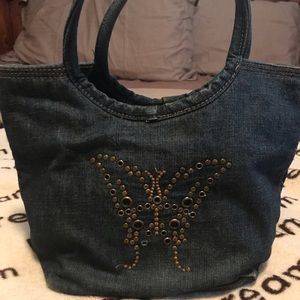 Denim shoulder bag with metal butterfly accent